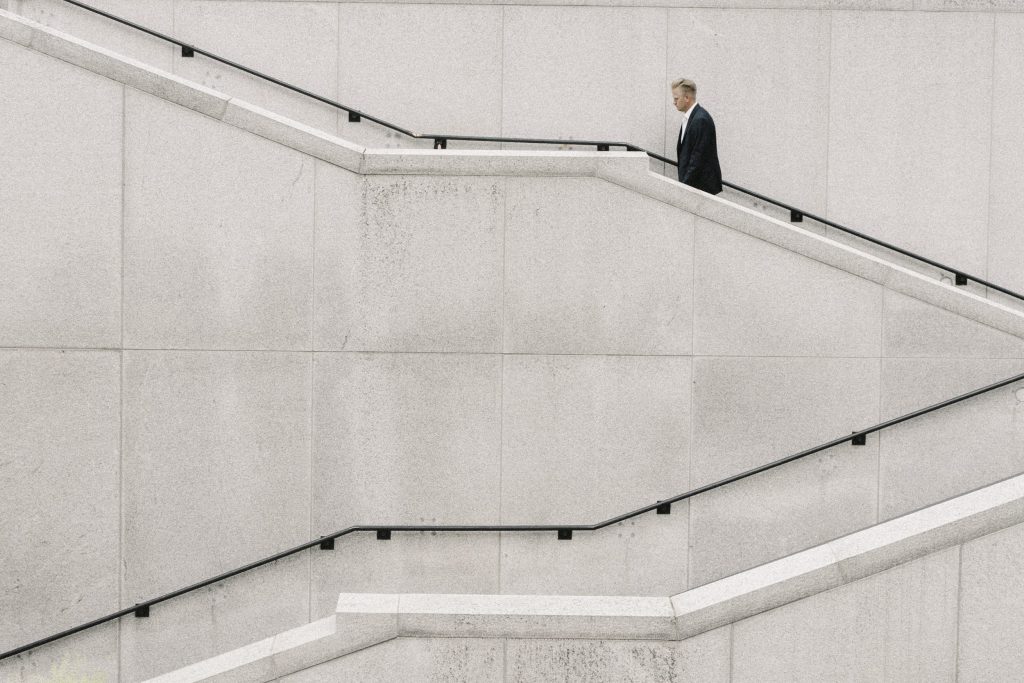 a shot of a man walking up the stair from the side