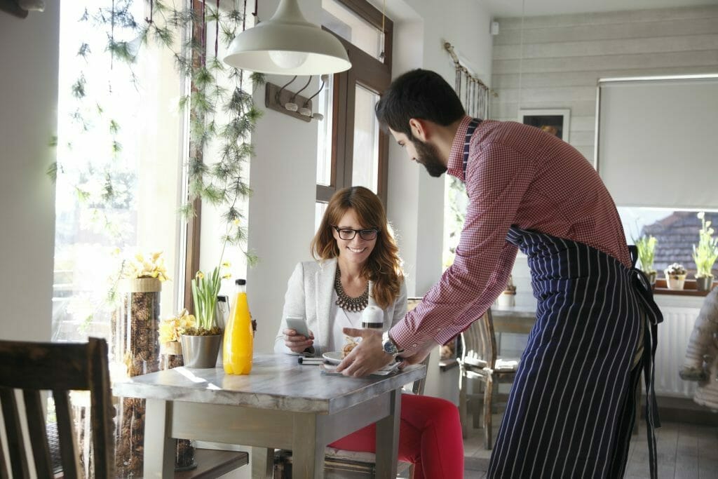 waiter greeting patron in restaurant