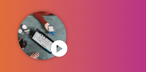 an aerial shot of a person paying using phone at a granite table with the POS system using a tablet